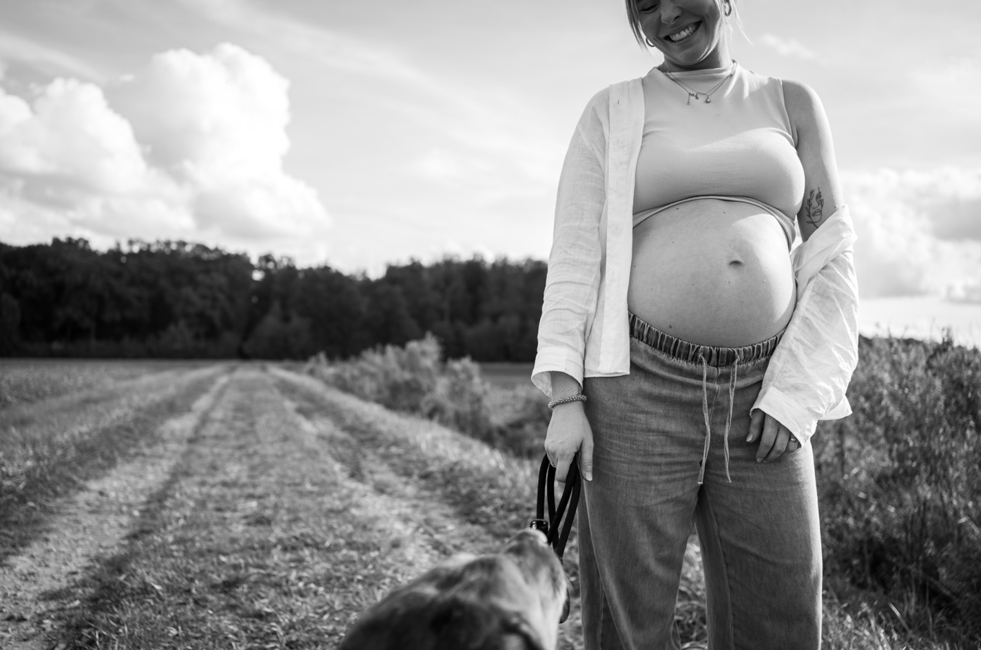 Schwangere Frau auf einem Feldweg, Schwarz-Weiß-Aufnahme